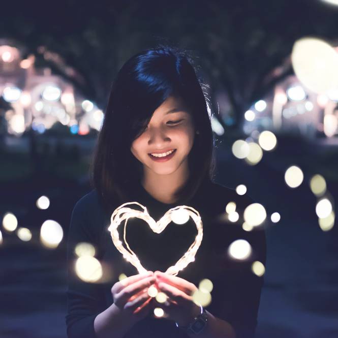 Woman holding a glowing heart