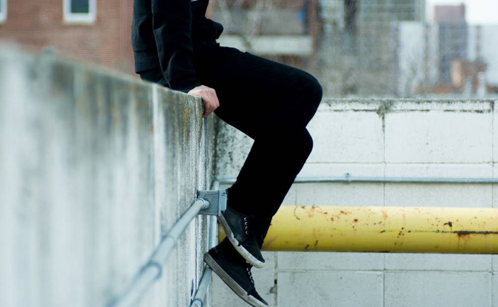 legs of a teenager sitting on a wall